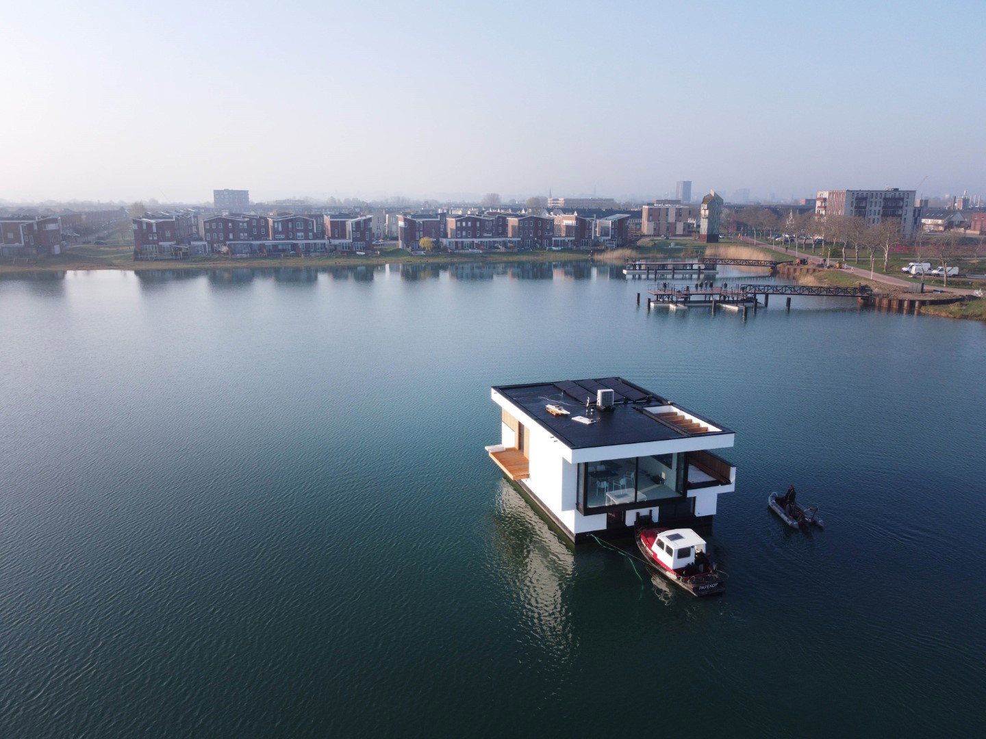 A finished Aqua Village floating home being tugged across the water to its mooring in Nijmegen