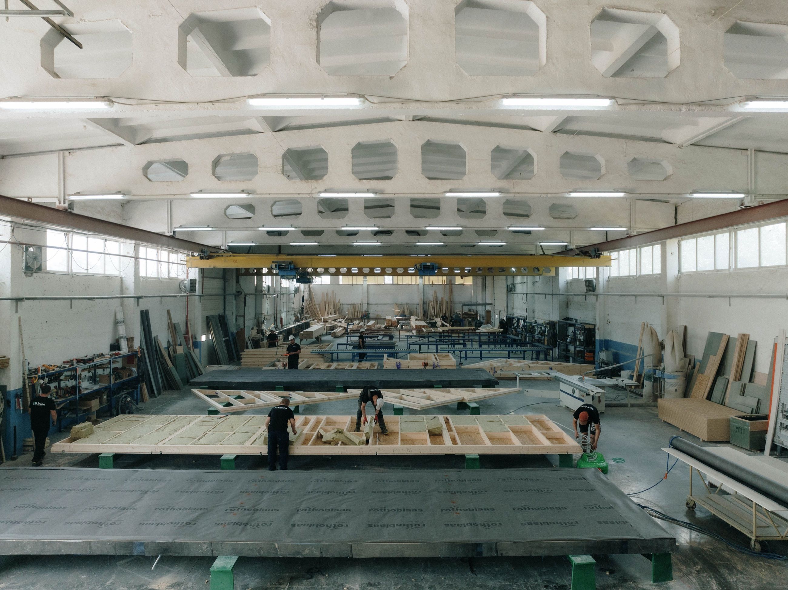 Timber-frame wall panels being built on the production line inside the Uniqa factory