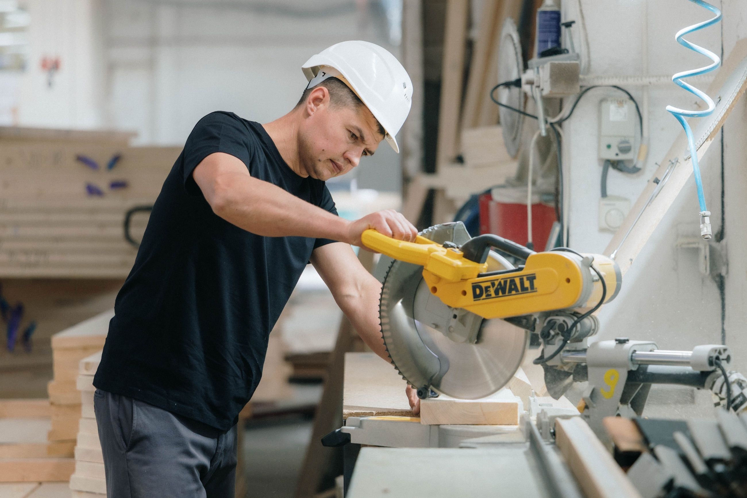 A Uniqa operator cutting timber components to size in the production hall